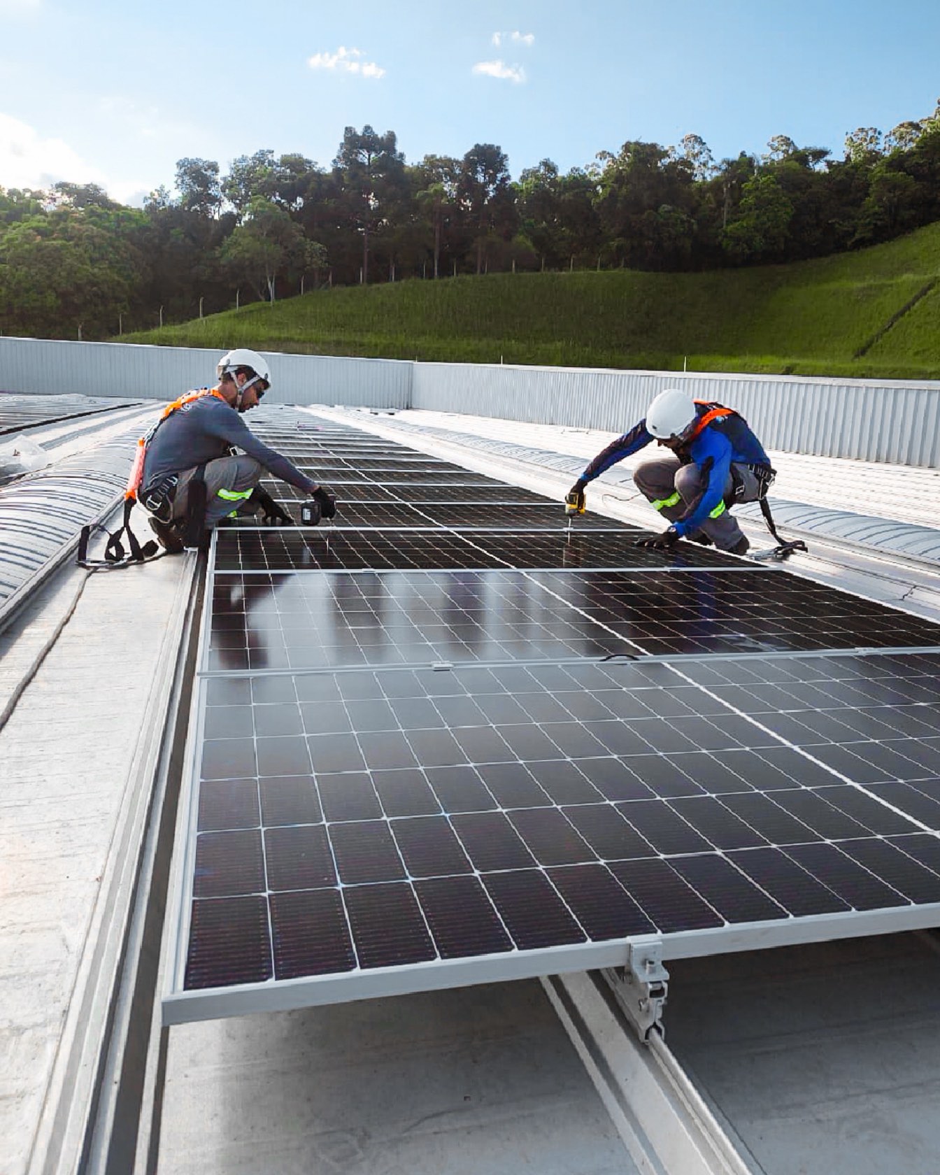 Instaladores da Sonnental montando módulos solares em um telhado industrial